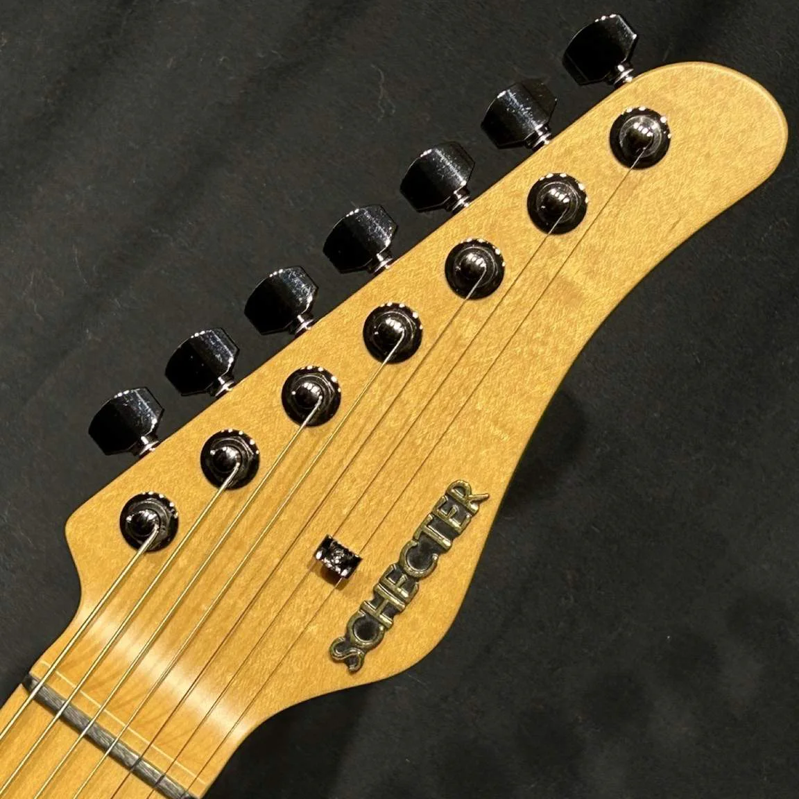 Schecter AC-EX-7-AveMujica/Mortis/SIG · Pink Glitter · Actual instrument, headstock front